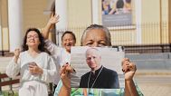 A woman holds a photo of Bishop Robert Prevost, who was elected Pope Leo XIV, in front of the Cathedral of Chiclayo, Peru, on 8 May, 2025.