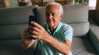 An older man takes a selfie.