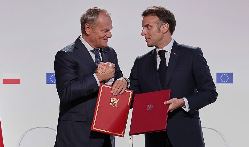 Premier Donald Tusk i prezydent Francji Emmanuel Macron uścisnęli sobie dłonie po podpisaniu traktatu o przyjaźni i wzmocnionej współpracy między oboma krajami, 2025 r.