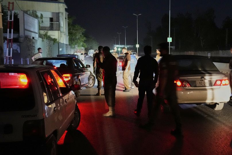 Pakistani police officers remove vehicles and people from the main entry of Nur Khan airbase following an Indian missile strike in Rawalpindi, Pakistan, Saturday, May 10, 2025