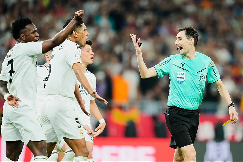 Real Madrid players argue with referee Ricardo De Burgos Bengoetxea during the Spanish Copa del Rey final