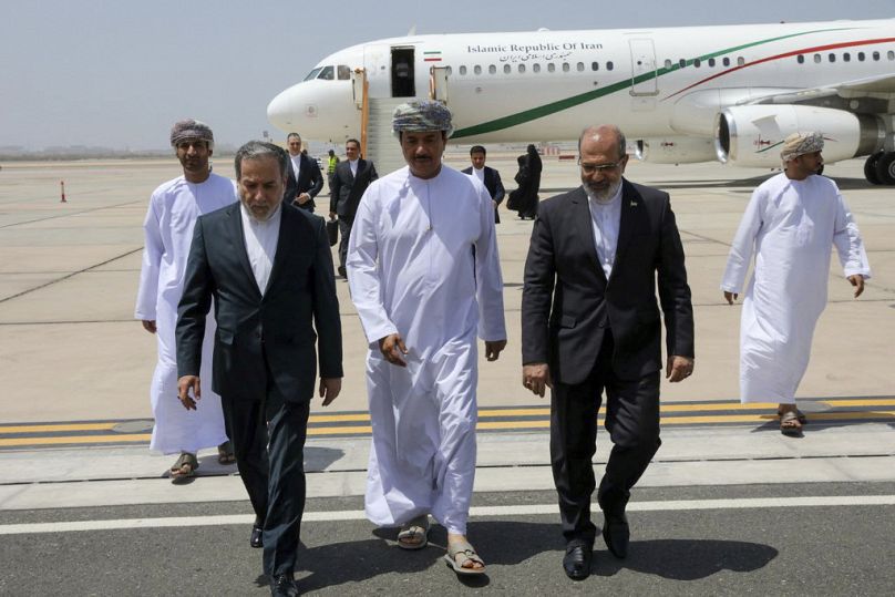 Iranian Foreign Minister Abbas Araghchi is welcomed by an unidentified Omani official center upon his arrival in Muscat, Oman prior to negotiations. Sunday, May 11, 2025. 