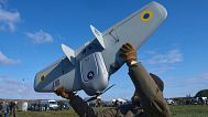 A manufacturer demonstrates a Ukrainian made drone at a Ukraine Defense Innovations exhibition for military clients on an undisclosed location in Ukraine, April 11, 2025.