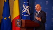 Romania's interim President Ilie Bolojan gestures during a press conference at the Cotroceni Presidential Palace in Bucharest.