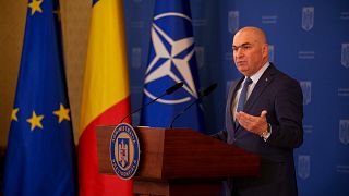 Romania's interim President Ilie Bolojan gestures during a press conference at the Cotroceni Presidential Palace in Bucharest.