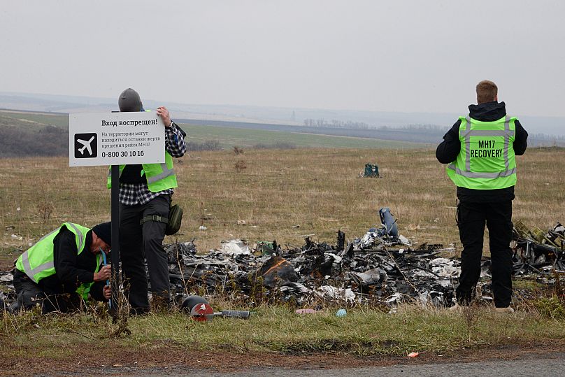 Helfer inspizieren den Unfallort der Maschine MH-17