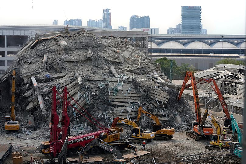 Heavy machinery is used to clear a pile of concrete from the site of a collapsed building in Bangkok, 2 April, 2025