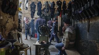 A shop owner sits inside his store in the old city market in Damascus, 9 January, 2025