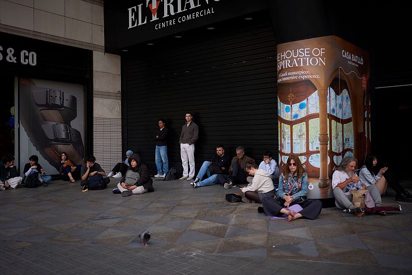 FILE: People wait outside a closed shopping centre during a blackout in Barcelona, 28 April 2025