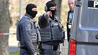 FILE: Officers from the police defusing service stand near a damaged vehicle on an access road to the Rhine bridge, in Mannheim, Germany, Monday, March 3, 2025