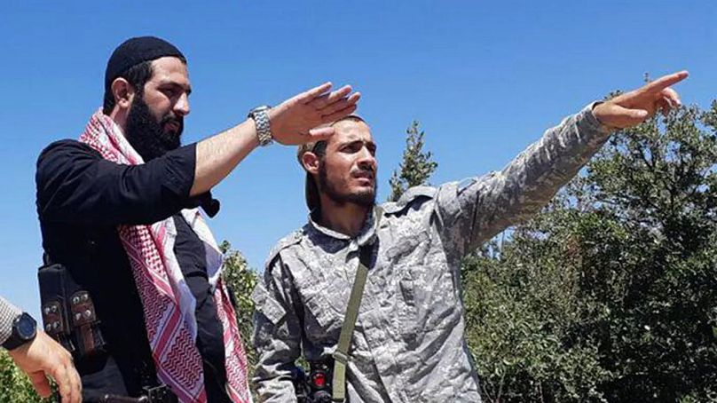 أحمد الشرع، زعيم هيئة تحرير الشام سابقًا وزعيم فرع تنظيم القاعدة في سوريا يتحدث مع أحد المقاتلين في ريف اللاذقية.