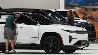 A shopper looks over a 2025 Jeep Wagoneer electric utility vehicle in the Stellantis display at the Colorado Auto Show, Denver. 17 April 2025.