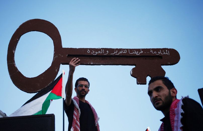 متظاهرون فلسطينيون يحملون مفتاحًا ضخمًا يرمز إلى حق العودة، خلال وقفة أمام السفارة الإسرائيلية في عمّان، الأردن، يوم الخميس 15 مايو 2014.