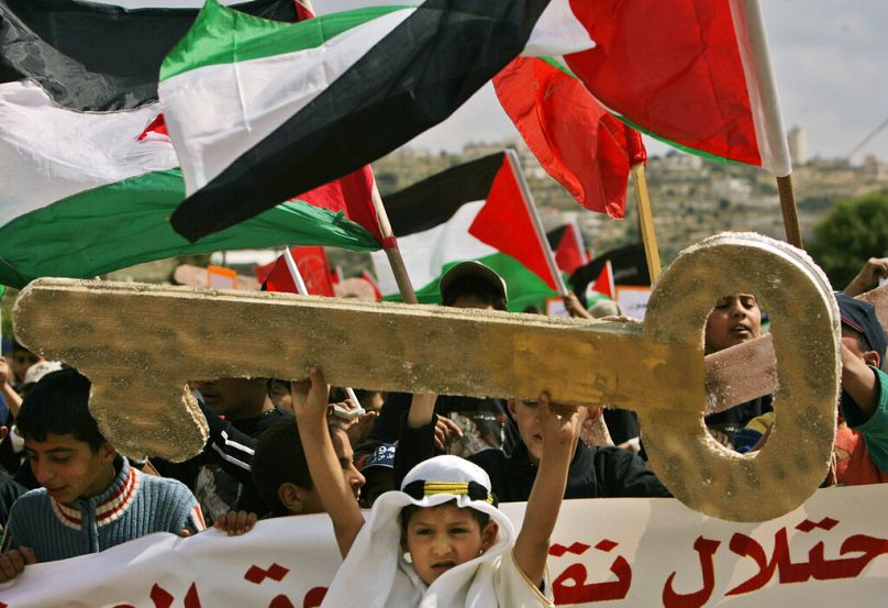 فتى فلسطيني يرتدي الزيّ التقليدي يحمل مفتاحًا رمزيًا كبيرًا، خلال تظاهرة لإحياء ذكرى النكبة، في الضفة الغربية، يوم الجمعة 9 مايو 2008.