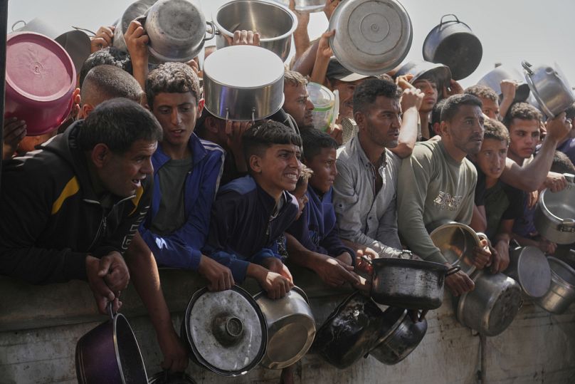 فلسطينيون يكافحون للحصول على الطعام في مطبخ جماعي بمدينة خان يونس جنوب قطاع غزة، الجمعة 9 أيار/مايو 2025.