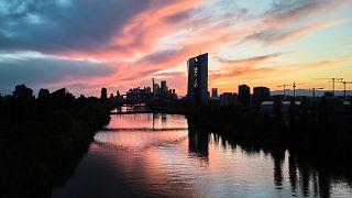 The sun sets behind the European Central Bank building, foreground centre, in Frankfurt, Germany. 26 April 2025.