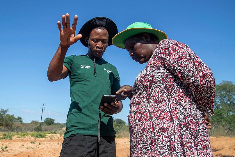 Capon Sibanda, left, talks with Senzeni Sibanda, a local councilor and farmer, in Hwange.