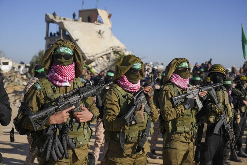 مقاتلو حماس يقفون بصفوف منظمة قبيل عملية الإفراج عن رهائن في خان يونس، جنوب قطاع غزة، 15 شباط/فبراير 2025.