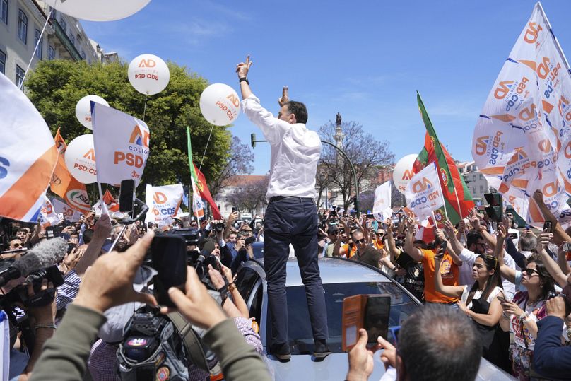  Der amtierende Ministerpräsident und Vorsitzende der Mitte-Rechts-Partei der Sozialdemokraten Luis Montenegro steht auf seinem Auto und gestikuliert vor seinen Anhängern.
