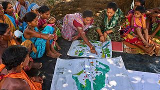 Kamala Kadria from the Gadaba Indigenous community points to a spot on a map they made in Hatipakna village, Koraput district, in India's eastern state of Odisha, April 2025.