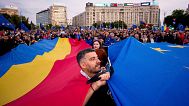 Demonstrators hold large Romanian and European Union flags during a pro-EU rally ahead of the second round of the presidential election redo in Bucharest, Romania, 9 May, 2025