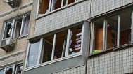 FILE: A resident looks out of the broken window in an apartment house following Russia's drone attack in Kyiv, 4 May 2025