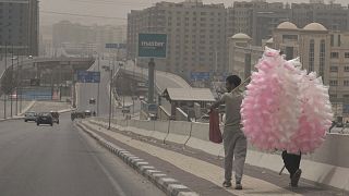 FILE: Cotton candy vendors walk during a dusty weather, before expected sandstorm, in Cairo, 30 April 2025