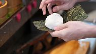 Yosuke Miura wraps seaweed around a rice ball at Onigiri Asakusa Yadoroku, Tokyo's oldest onigiri restaurant, 3 June 2025.