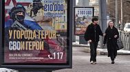 FILE: A couple walk past billboards calling for a contract for service in the Russian armed forces in St Petersburg, 15 March 2025