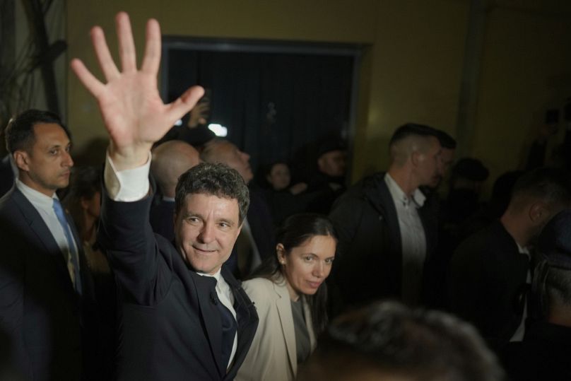 Le nouveau président roumain Nicusor Dan salue ses partisans après la fermeture des bureaux de vote pour le second tour.