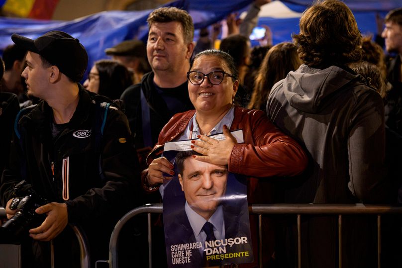 Une partisane du candidat présidentiel Nicusor Dan tient une affiche électorale après sa victoire au second tour.