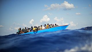 FILE - Migrants sail a wooden boat at south of the Italian Lampedusa island at the Mediterranean sea, Aug. 11, 2022.