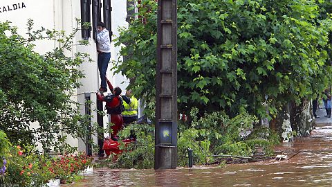 Una squadra di soccorso aiuta un uomo a uscire dalla sua casa a Cambo-Les-Bains, nel sud-ovest della Francia, venerdì 4 luglio 2014.
