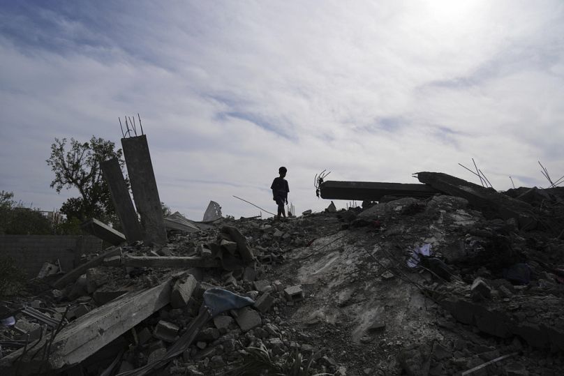 Un enfant palestinien marche sur les décombres de sa maison à Khan Younis, dans la bande de Gaza, le jeudi 15 mai 2025.