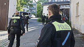 FILE: Police officers search buildings following the ban of the Reichsbürger group "Kingdom of Germany" in Gera, Germany, Tuesday, May 13, 2025