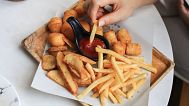 A person eats fries.