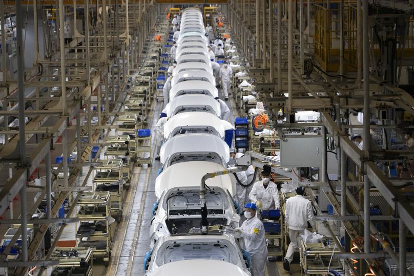 Des employés travaillent sur une chaîne de montage de voitures à l'usine Dongfeng Honda Automobile Co.