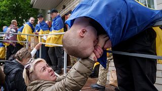 A Ukrainian soldier kisses a hand of a woman after returning from captivity in a POW exchange in Ukraine, Tuesday, May 6, 2025.