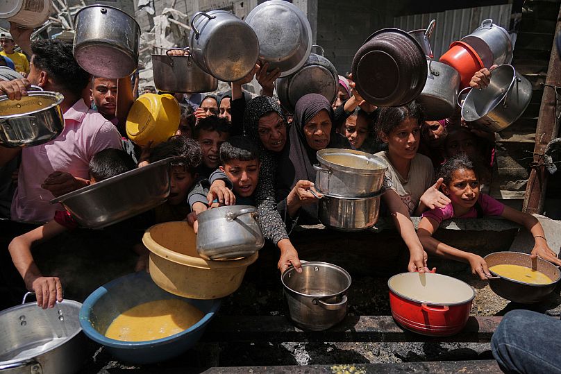 Des Palestiniens luttent pour obtenir de la nourriture dans une cuisine communautaire à Jabalia, dans le nord de la bande de Gaza, le lundi 19 mai 2025
