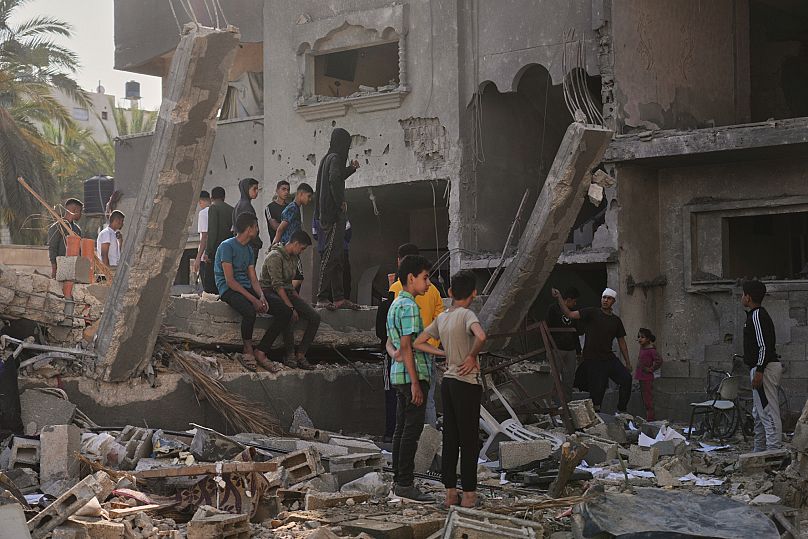 Palestinians inspect a house destroyed by an Israeli air strike in Deir al-Balah, 21 May, 2025