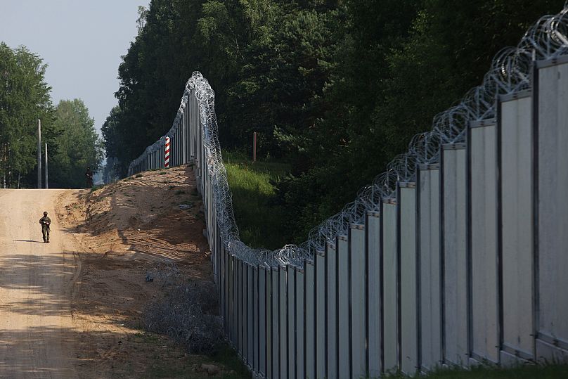 Un garde-frontière polonais patrouille le long d'un mur construit à la frontière entre la Pologne et le Bélarus, près de Kuznice, en Pologne, le jeudi 30 juin 2022