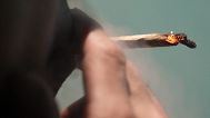 A tourist smokes cannabis at a Dutch passion shop in Bangkok, 27 June, 2023