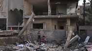 Palestinians inspect a house destroyed by an Israeli air strike in Deir al-Balah, 21 May, 2025