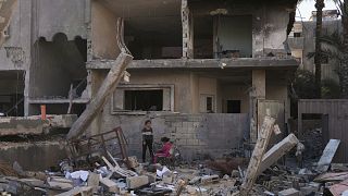 Palestinians inspect a house destroyed by an Israeli air strike in Deir al-Balah, 21 May, 2025