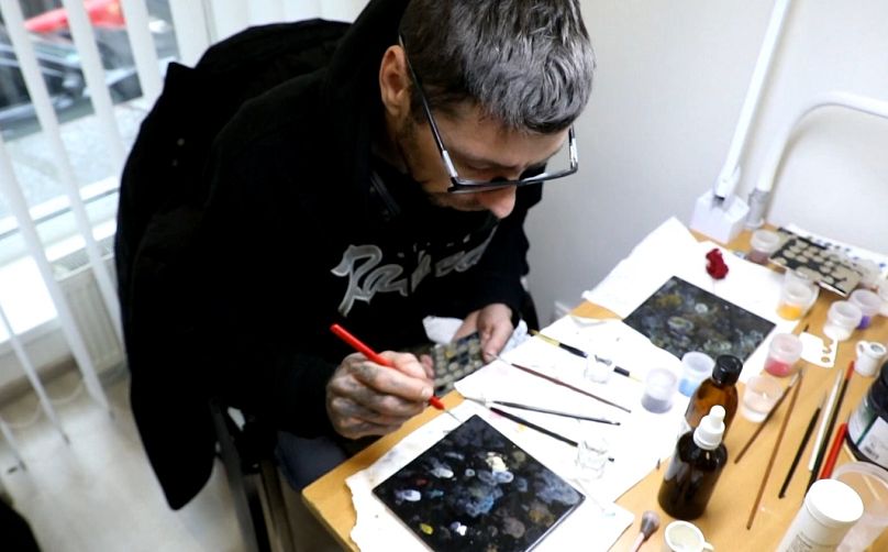 Un artista pinta un ojo protésico.