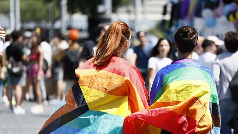 Persone avvolte in bandiere arcobaleno prendono parte alla parata dell'orgoglio LGBTQ+ a Roma, 10 giugno 2023