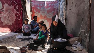 Nouf Al-Arja, 30, who suffers from malnutrition, cooks for her family inside their tent in a camp for displaced Palestinians in Muwasi, Khan Younis, Gaza, 21.05.2025