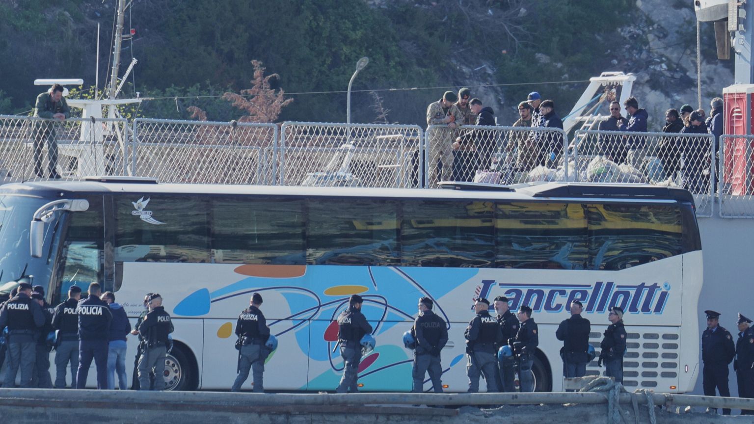 A bus waits to transfer migrants arriving onboard the Italian navy ship Lybra in Shengjin, Albania, 11 April 2025