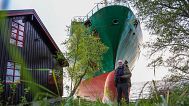 Johan Helberg stands next to his house with the container ship NCL Salten in the background in the Trondheimsfjord, 22 May, 2025 