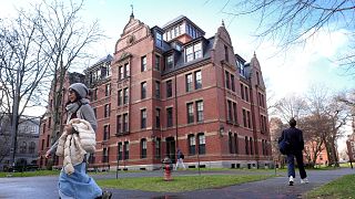 People walk between buildings, Dec. 17, 2024, on the campus of Harvard University in Cambridge, Mass.